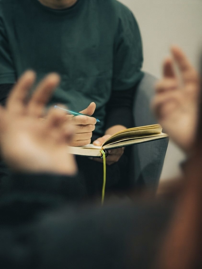 Psicólogo tomando notas durante una sesión de psicoterapia